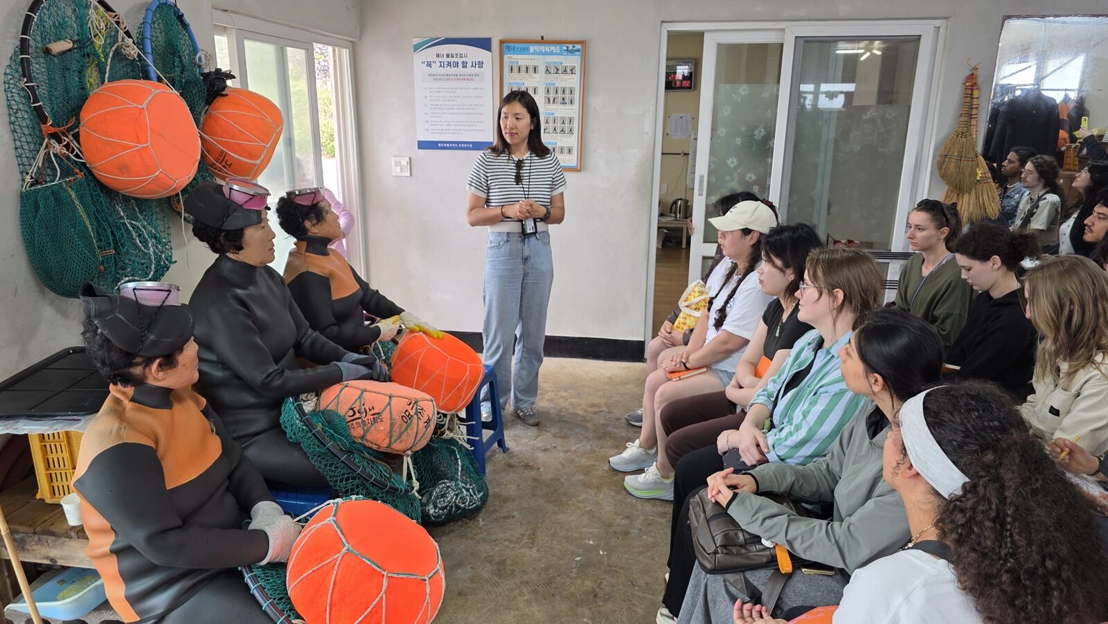 A Jeju haenyeo speaking with guests during a village visit